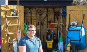 Tom West - CEO of RentMy, in front of a shed full of tools.