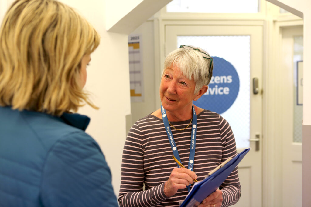 Woman holding a clipboard and wearing a Citizens Advice lanyard