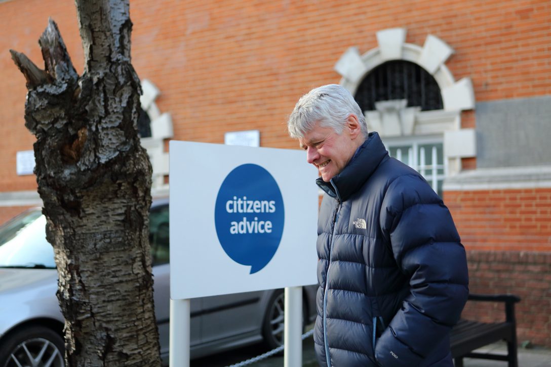 Happy mature man outside Citizens Advice office